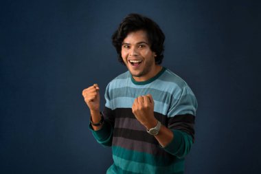 Young handsome man over dark background afraid and shocked with surprise and amazed expression, fear and excited face.