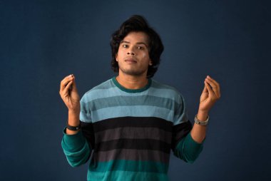 Young handsome man over dark background afraid and shocked with surprise and amazed expression, fear and excited face.