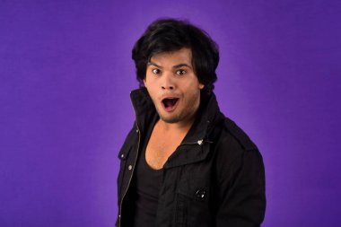 Young handsome man over dark background afraid and shocked with surprise and amazed expression, fear and excited face.