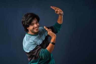 Young handsome man over dark background afraid and shocked with surprise and amazed expression, fear and excited face.