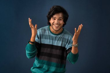 Young handsome man over dark background afraid and shocked with surprise and amazed expression, fear and excited face.