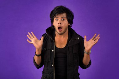 Young handsome man over dark background afraid and shocked with surprise and amazed expression, fear and excited face.