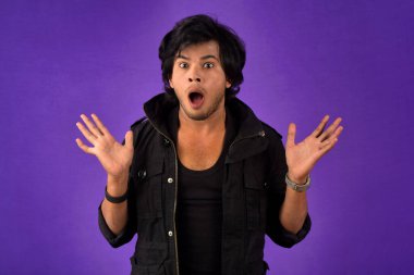 Young handsome man over dark background afraid and shocked with surprise and amazed expression, fear and excited face.