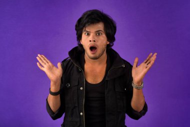 Young handsome man over dark background afraid and shocked with surprise and amazed expression, fear and excited face.