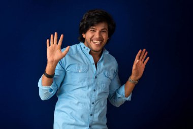 Young handsome man over dark background afraid and shocked with surprise and amazed expression, fear and excited face.