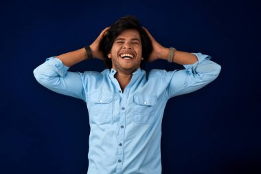 Young handsome man over dark background afraid and shocked with surprise and amazed expression, fear and excited face.