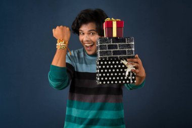 Young men showing Rakhi on his hand with gift box on the occasion of Raksha Bandhan festival