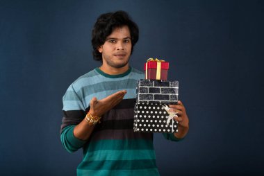 Young men showing Rakhi on his hand with gift box on the occasion of Raksha Bandhan festival