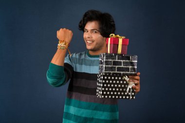 Young men showing Rakhi on his hand with gift box on the occasion of Raksha Bandhan festival