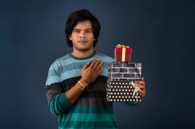 Young men showing Rakhi on his hand with gift box on the occasion of Raksha Bandhan festival