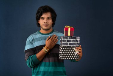 Young men showing Rakhi on his hand with gift box on the occasion of Raksha Bandhan festival