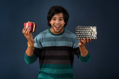 Young men showing Rakhi on his hand with gift box on the occasion of Raksha Bandhan festival