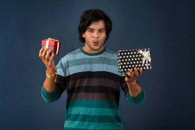 Young men showing Rakhi on his hand with gift box on the occasion of Raksha Bandhan festival