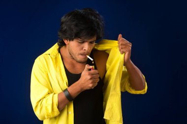 A young man smoking a cigarette and making a lot of smoke around.