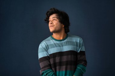 Portrait of a young man thinking on a dark background