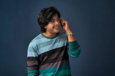 Portrait of a young man thinking on a dark background