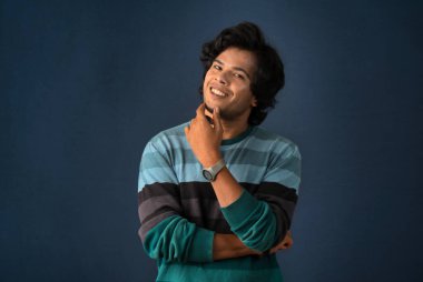 Portrait of a young man thinking on a dark background