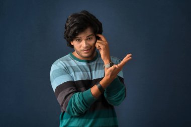 Portrait of a young man thinking on a dark background