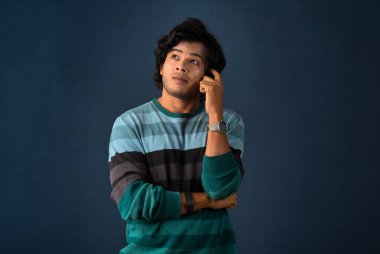 Portrait of a young man thinking on a dark background