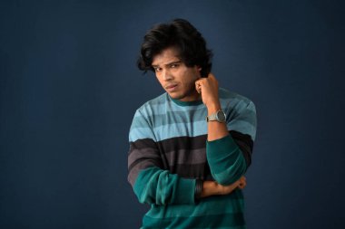 Portrait of a young man thinking on a dark background