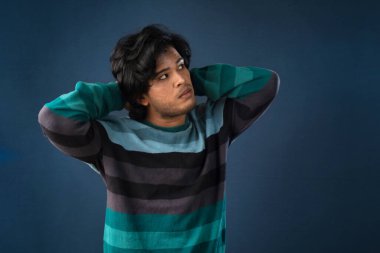 Portrait of a young man thinking on a dark background