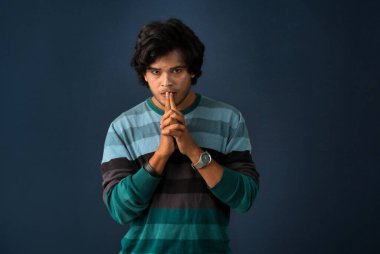 Portrait of a young man thinking on a dark background