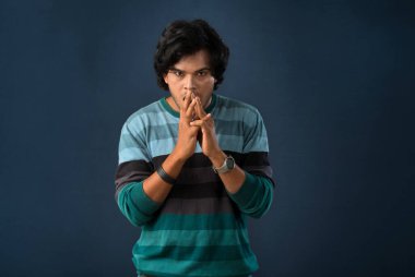 Portrait of a young man thinking on a dark background