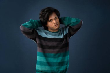 Portrait of a young man thinking on a dark background