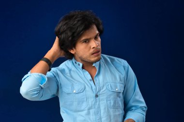 Portrait of a young man thinking on a dark background