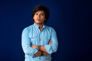 Portrait of a young man thinking on a dark background