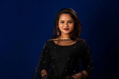 Portrait of a young girl or woman posing on blue background