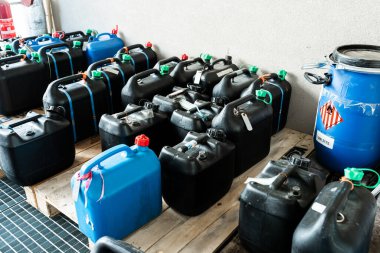 Metal and plastic barrels containing hazardous chemicals from industry, waste management concept, industrial background