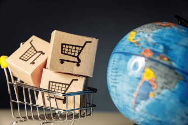 Süpermarket alışveriş arabalı, kutuları yakın çekim olan bir dünya. Dünya ticareti ve alım satımları