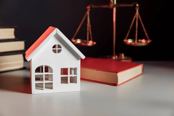 Продажа концепции недвижимости. Деревянная модель дома и книги законов — стоковое фото