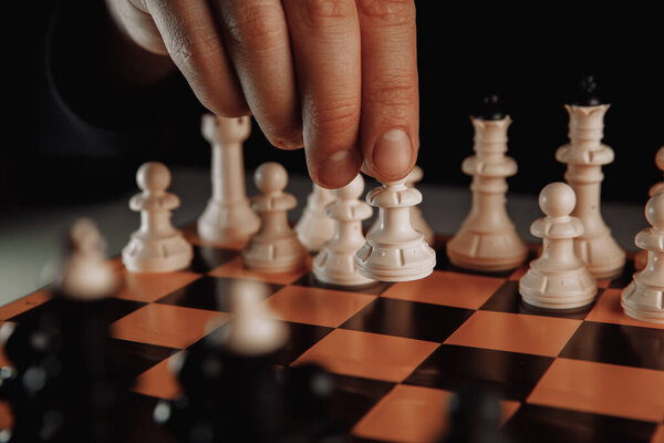 Бизнесмен перемещает фигурку шахматиста-паука. Концепция бизнес стратегии