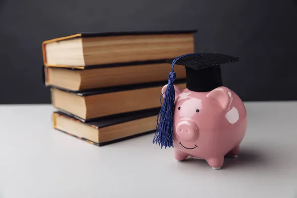 Roze spaarpot met boeken. College, diploma, onderwijsconcept — Stockfoto