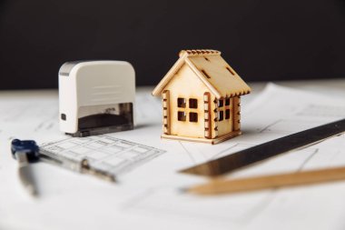 Ahşap evi olan planlar, masaya yakın plan araçlar ve gözlükler.