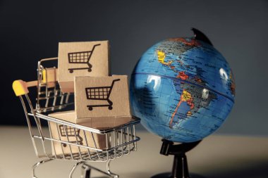 Çevrimiçi alışveriş ve ecommerce konsepti. Kutuları olan dünya ve süpermarket alışveriş arabası.