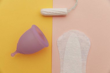 Adet bardağı, tampon ve ped yakın çekim. Kadın hijyeni konsepti