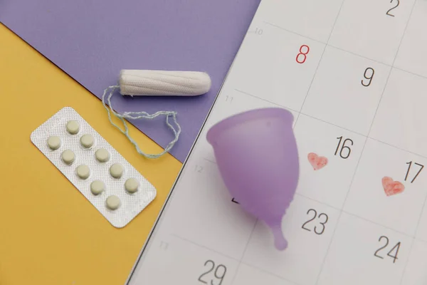 Calendario, tampone e coppetta mestruale con antidolorifici primo piano — Foto Stock