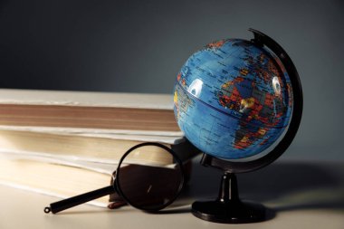 Küresel eğitim kavramı. Kitaplı büyüteç ve küre