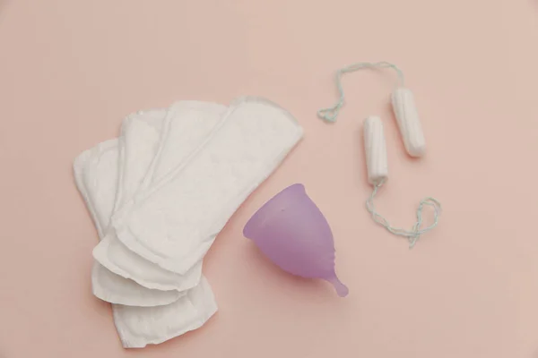 Pad, menstruatiecup, tampon op een roze achtergrond. Concept van kritieke dagen en hygiëne — Stockfoto