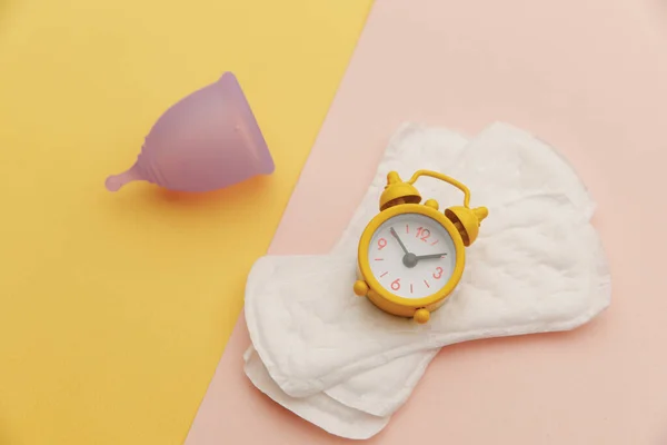 目覚まし時計付きの精神的なカップとパッド。女性衛生の概念 — ストック写真