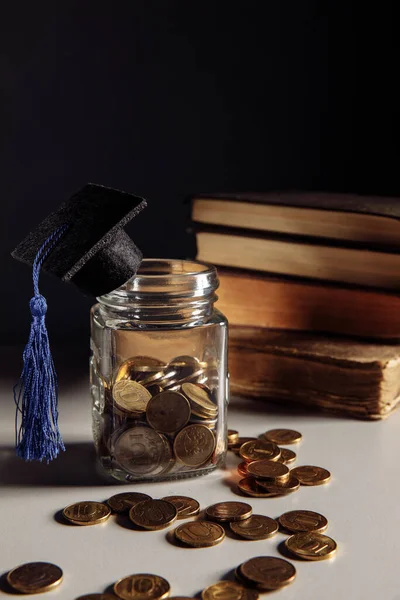 Épargne pour l'éducation concept. Pièces de monnaie en pot avec bouchon de graduation. Image verticale — Photo