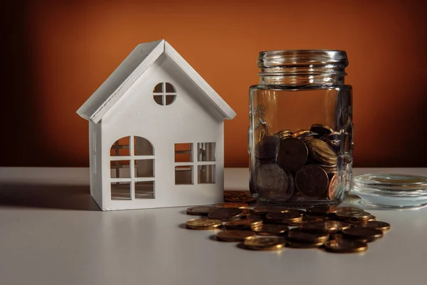 Modelo de casa y frasco de vidrio con monedas, concepto financiero e hipotecario — Foto de Stock