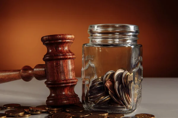 Coins from a jar and legal gavel on a table close-up — Stock Photo, Image