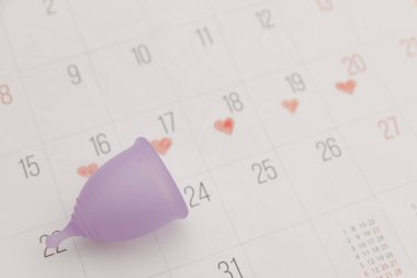 Takvim ve mor regl kupası. Kadın hijyeni, regl dönemi, kritik günler konsepti