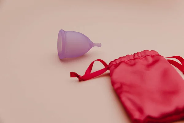 Herbruikbare pastelpaarse menstruatiecup op een roze achtergrond. Milieuvriendelijke manier van vrouwenhygiëne, menstruatie, kritieke dagen — Stockfoto