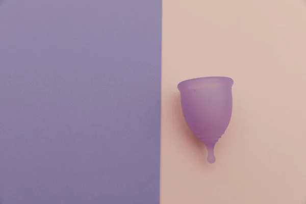 Herbruikbare pastelpaarse menstruatiecup op een kleurrijke achtergrond. Vrouwenhygiëne, menstruatie, kritieke dagen — Stockfoto