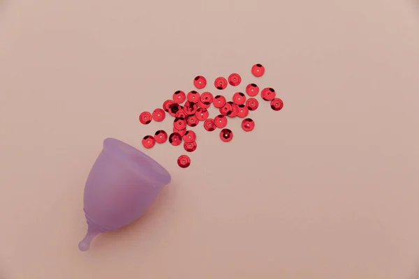 Hygienic menstrual cup in spray of puddle of red shining sequins, symbol of blood — Foto Stock